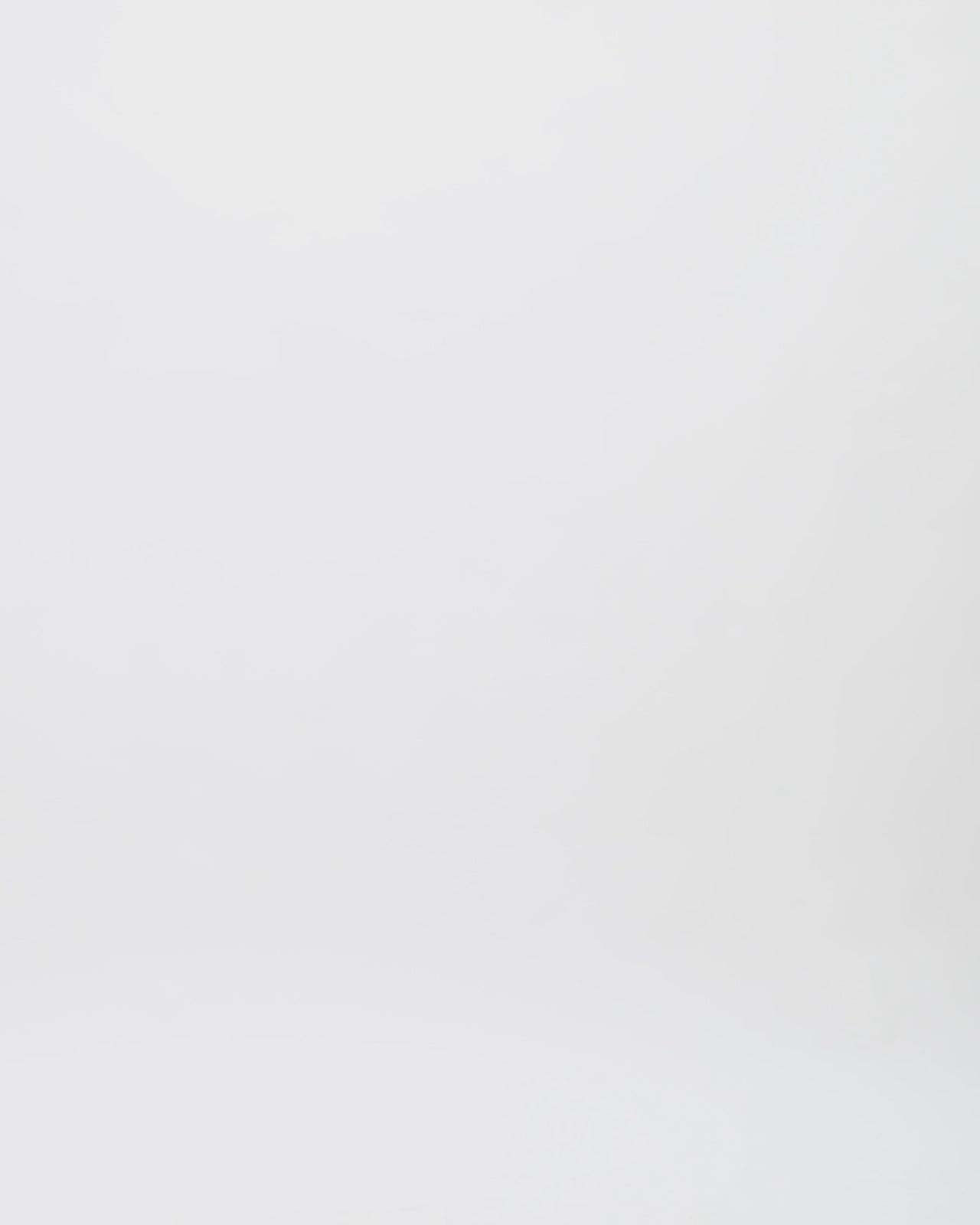 A kaftan-style black dress with a crepe fold-over at the neckline and white beading details on the shoulders.