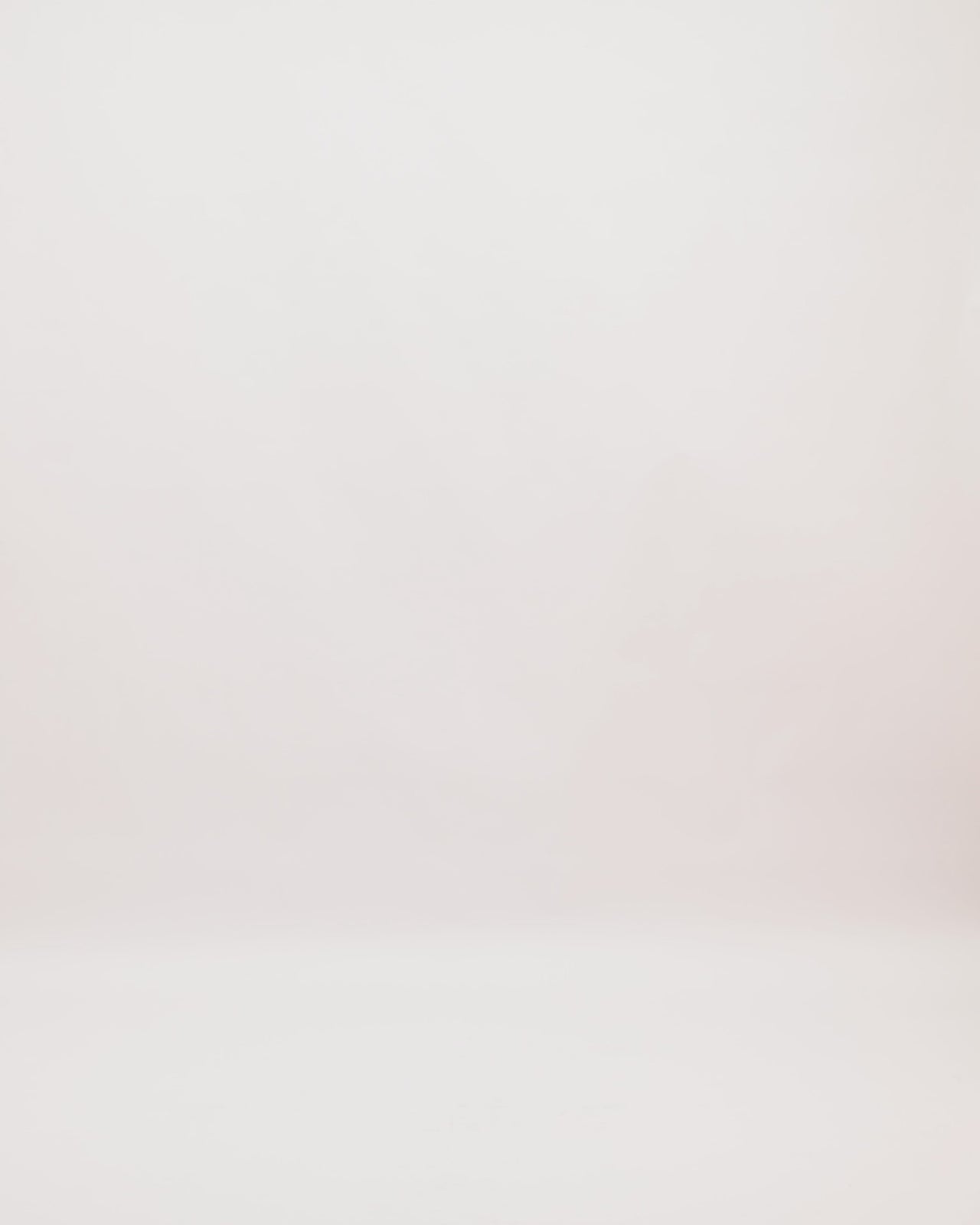 A halter-neckline evening dress with a multicolor floral guipure corset and a long orange crepe cape.