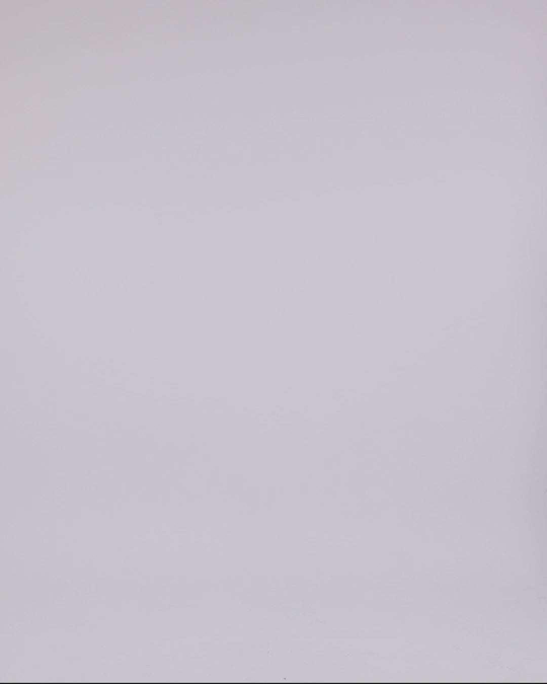 A strapless grey jumpsuit featuring a beaded neckline, draping on the waist and a ruffled slit on one leg.