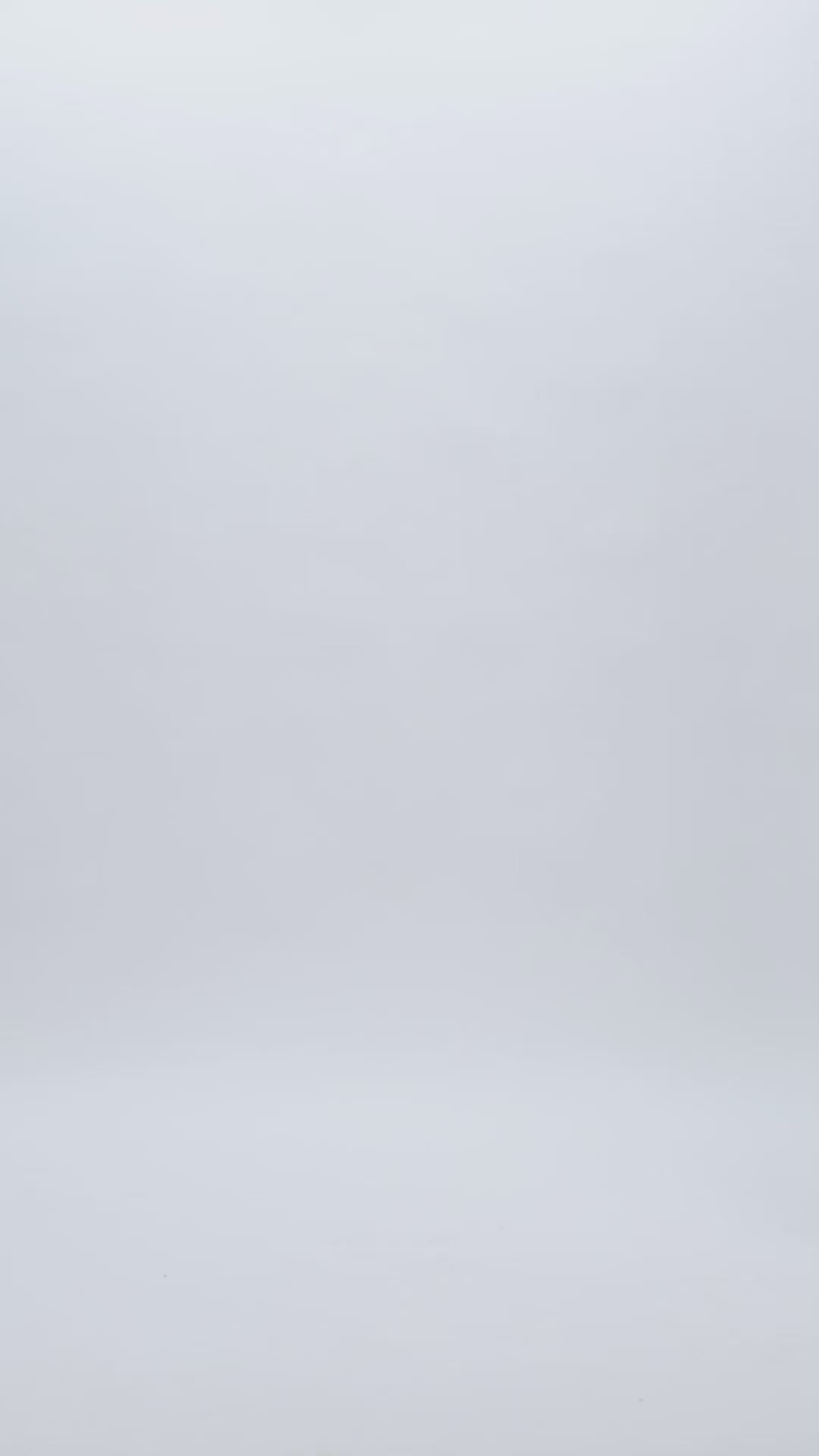 A short-sleeve dress featuring an asymmetrical laser-cut heavy satin detail on the bodice going down to the hip, with cuts showing some skin. A round open back, under the asymmetrical design comes a long tulle skirt.