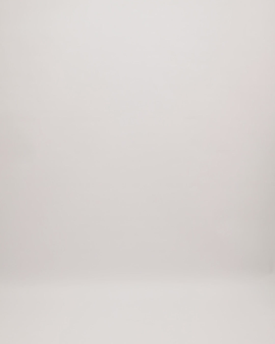 A one-shoulder draped evening dress in mustard with beadings on the neckline and an open slit on the side.